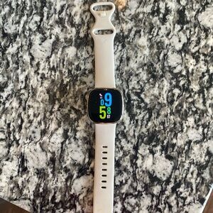 Fitbit Sense with watch band and chargers.